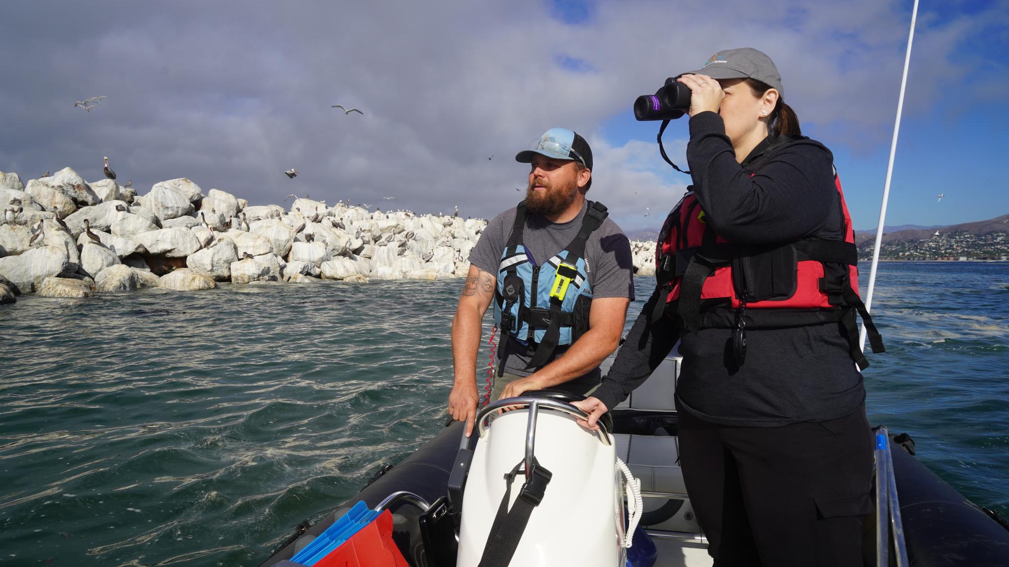 Danny Vickers and Victoria Hall on a boat surveying waters for oiled wildlife
