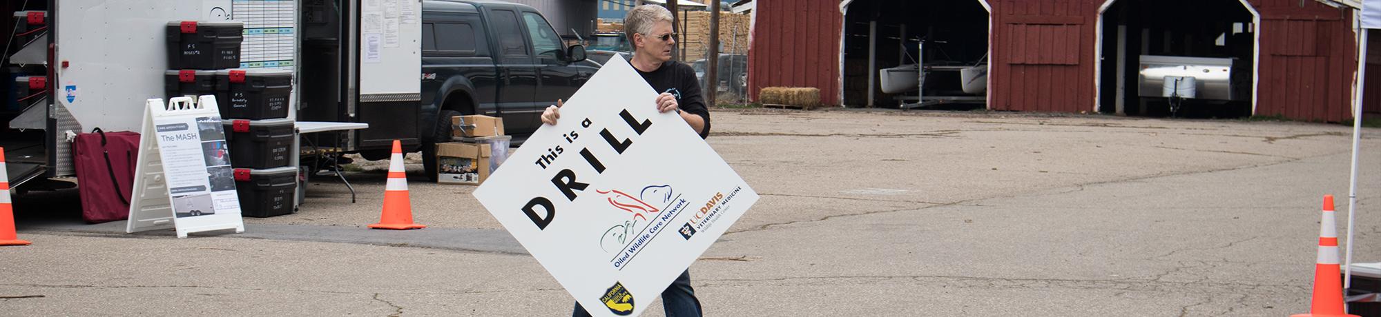 Michael Ziccardi carrying drill sign